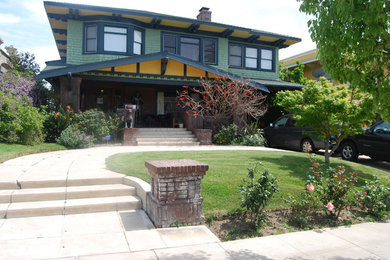 Example of a mid-sized arts and crafts green two-story wood house exterior design in Los Angeles with a hip roof