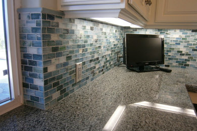 Kitchen - small traditional kitchen idea in San Diego with beaded inset cabinets, white cabinets, granite countertops and glass tile backsplash