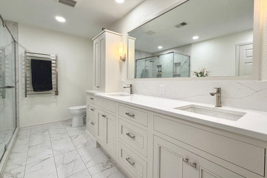 Large master white tile and porcelain tile porcelain tile, gray floor and double-sink bathroom photo in Milwaukee with white cabinets, white walls, an undermount sink, quartz countertops, a hinged shower door, white countertops and a freestanding vanity