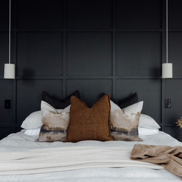 Moody Bedroom with Dark Wall Panelling and Layered Neutral Bedding