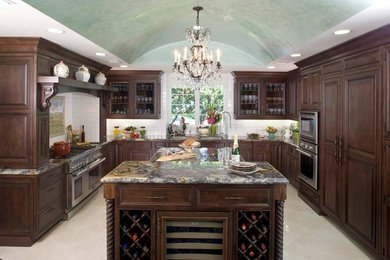 Example of a large classic u-shaped travertine floor eat-in kitchen design in Los Angeles with a double-bowl sink, beaded inset cabinets, dark wood cabinets, granite countertops, brown backsplash, porcelain backsplash, stainless steel appliances and an island