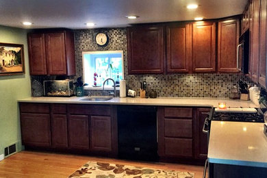 Example of a mid-sized eclectic l-shaped light wood floor eat-in kitchen design in Detroit with an undermount sink, raised-panel cabinets, dark wood cabinets, quartzite countertops, multicolored backsplash, glass tile backsplash, stainless steel appliances and no island