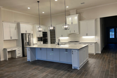 Eat-in kitchen - large craftsman l-shaped ceramic tile and brown floor eat-in kitchen idea in Houston with shaker cabinets, white cabinets, an island, an undermount sink, granite countertops, white backsplash, subway tile backsplash, stainless steel appliances and white countertops