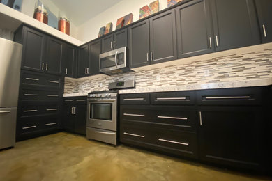 Large modern l-shaped kitchen in Sacramento with shaker cabinets, black cabinets, granite benchtops, multi-coloured splashback, matchstick tile splashback and stainless steel appliances.