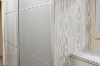 Стильный дизайн: узкая прихожая в современном стиле с бежевыми стенами и полом из ламината - последний тренд