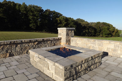 Photo of a large contemporary backyard patio in Chicago with a fire feature, brick pavers and no cover.