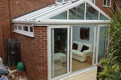 Inspiration for a mid-sized traditional sunroom in Surrey with light hardwood floors and a glass ceiling.