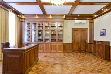 На фото: большой домашняя библиотека в стиле неоклассика (современная классика) с отдельно стоящим рабочим столом с
