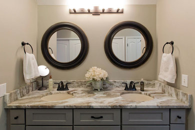 Example of a mid-sized transitional master porcelain tile and brown floor bathroom design in Cleveland with shaker cabinets, gray cabinets, a two-piece toilet, beige walls, an undermount sink, quartzite countertops, a hinged shower door and beige countertops