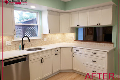 Example of a mid-sized transitional l-shaped laminate floor and brown floor kitchen design in Wilmington with an undermount sink, flat-panel cabinets, white cabinets, quartz countertops, beige backsplash, porcelain backsplash, stainless steel appliances, no island and white countertops