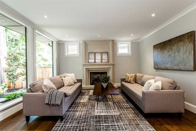Inspiration for a mid-sized transitional formal and enclosed dark wood floor and brown floor living room remodel in Vancouver with gray walls, a standard fireplace, a plaster fireplace and no tv