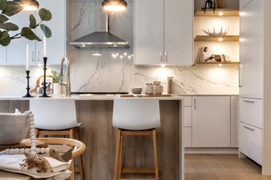 Mid-sized contemporary single-wall eat-in kitchen in Vancouver with an undermount sink, flat-panel cabinets, white cabinets, quartz benchtops, white splashback, engineered quartz splashback, panelled appliances, medium hardwood floors, with island, brown floor and white benchtop.