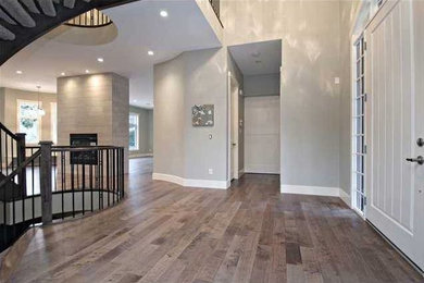 Inspiration for a large contemporary medium tone wood floor and brown floor entryway remodel in Calgary with gray walls and a white front door