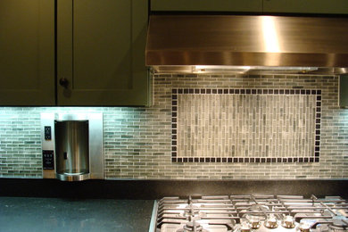 Example of a minimalist kitchen design in Seattle with green cabinets, granite countertops, green backsplash and glass sheet backsplash