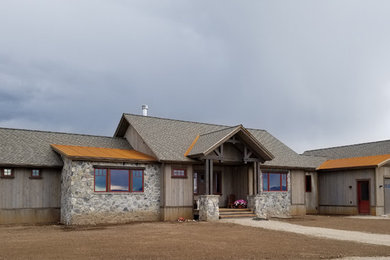 Photo of a large country two-storey brown house exterior in Other with mixed siding, a gable roof, a shingle roof, a grey roof and board and batten siding.