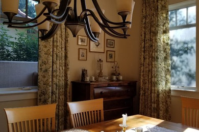 Immagine di una sala da pranzo tradizionale chiusa e di medie dimensioni con pareti beige, pavimento in legno massello medio e nessun camino