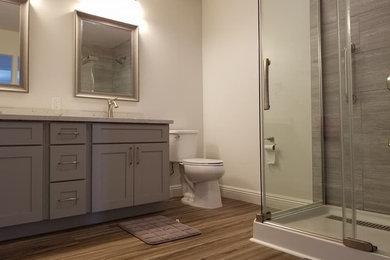 Example of a mid-sized transitional 3/4 gray tile and porcelain tile medium tone wood floor and brown floor bathroom design in Hawaii with shaker cabinets, brown cabinets, a two-piece toilet, white walls, an undermount sink, granite countertops and gray countertops