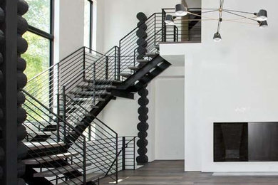 Example of a large trendy wooden floating open and metal railing staircase design in Other