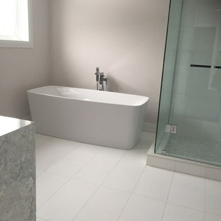 Ispirazione per una grande stanza da bagno padronale minimalista con vasca freestanding, pareti beige, piastrelle bianche, pavimento in vinile, doccia ad angolo, pavimento bianco e porta doccia a battente
