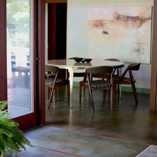 Inspiration pour une salle à manger ouverte sur la cuisine traditionnelle de taille moyenne avec un mur vert, béton au sol, une cheminée standard, un manteau de cheminée en brique et un sol vert.