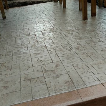 J-Stamped concrete patio with a step under the wood deck