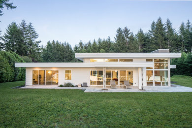 Mid-sized modern one-storey white house exterior in Seattle with wood siding and a flat roof.