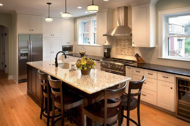 Inspiration for a galley medium tone wood floor eat-in kitchen remodel in Chicago with an undermount sink, recessed-panel cabinets, white cabinets, granite countertops, multicolored backsplash, matchstick tile backsplash, stainless steel appliances and an island