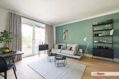 Kleines, Offenes Modernes Wohnzimmer mit grüner Wandfarbe, hellem Holzboden und beigem Boden in München