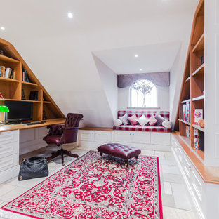 Design ideas for a mid-sized transitional study room in Other with white walls, limestone floors, a built-in desk and no fireplace.