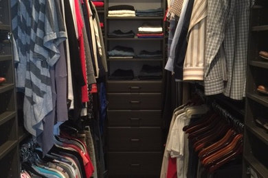 Example of a large trendy men's carpeted and brown floor walk-in closet design in Salt Lake City with flat-panel cabinets