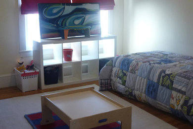 Modelo de dormitorio infantil clásico de tamaño medio con paredes blancas, suelo de madera en tonos medios y suelo marrón
