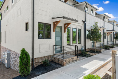 Large modern beige three-story concrete fiberboard and clapboard exterior home idea in Atlanta with a metal roof and a brown roof