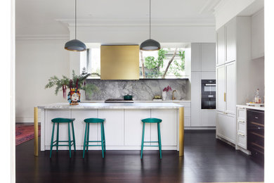 This is an example of a mid-sized transitional open plan kitchen in Melbourne with a double-bowl sink, white cabinets, marble benchtops, multi-coloured splashback, marble splashback, black appliances, dark hardwood floors, with island, brown floor, white benchtop and shaker cabinets.