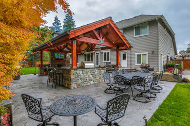 Inspiration for a large arts and crafts backyard patio in Seattle with an outdoor kitchen, concrete slab and a roof extension.