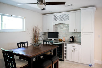 Photo of a small contemporary single-wall home bar in Miami with shaker cabinets, white cabinets, granite benchtops, grey splashback, mosaic tile splashback and ceramic floors.