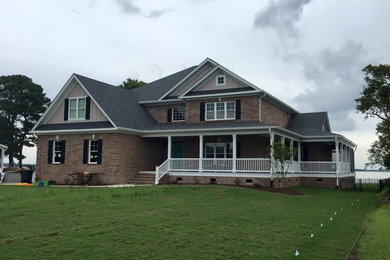 Inspiration for a large coastal brown two-story brick gable roof remodel in Other