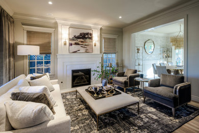 Example of a transitional formal and enclosed medium tone wood floor and brown floor living room design in San Francisco with white walls, a standard fireplace and a stone fireplace