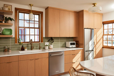 Example of a mid-sized danish galley porcelain tile and gray floor enclosed kitchen design in Minneapolis with an undermount sink, flat-panel cabinets, light wood cabinets, quartz countertops, green backsplash, ceramic backsplash, stainless steel appliances, a peninsula and white countertops
