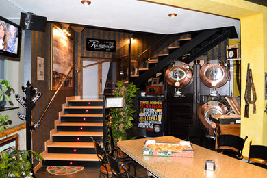 Foto de escalera en U contemporánea de tamaño medio con escalones de madera, contrahuellas de metal y barandilla de vidrio