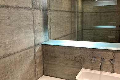 Modelo de cuarto de baño principal, único y gris y blanco urbano pequeño con bañera encastrada, baldosas y/o azulejos grises, paredes grises, suelo de baldosas de porcelana, lavabo suspendido, suelo gris y ducha abierta