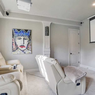 Photo of a small classic enclosed home cinema in New Orleans with grey walls, carpet, a projector screen and grey floors.