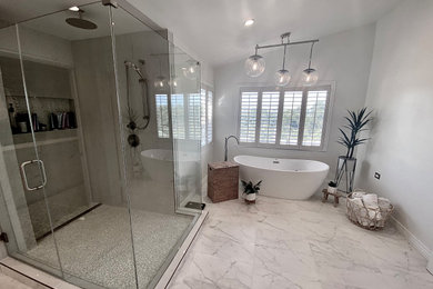 Large minimalist master multicolored tile and porcelain tile porcelain tile, multicolored floor and double-sink bathroom photo in Los Angeles with recessed-panel cabinets, light wood cabinets, a one-piece toilet, gray walls, quartzite countertops, white countertops and a freestanding vanity