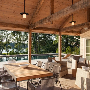 This is an example of a country patio in Boston with a roof extension.
