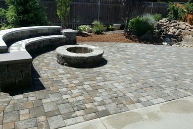 Patio - large traditional backyard stone patio idea in Boise with a fire pit and no cover
