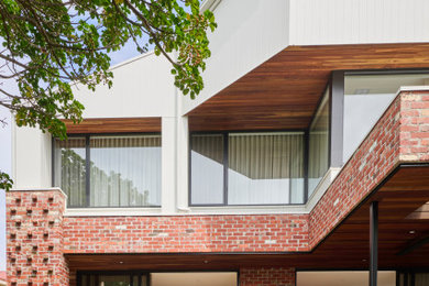 Large contemporary two-storey brick house exterior in Geelong with a clipped gable roof, a metal roof and a white roof.