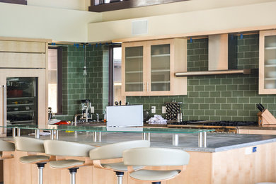 Large minimalist l-shaped kitchen photo in Denver with glass-front cabinets, light wood cabinets, green backsplash, subway tile backsplash, paneled appliances and gray countertops