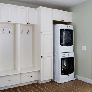 ワシントンD.C.の中サイズのトランジショナルスタイルのおしゃれな家事室 (レイズドパネル扉のキャビネット、白いキャビネット、クッションフロア、上下配置の洗濯機・乾燥機、茶色い床、グレーの壁) の写真