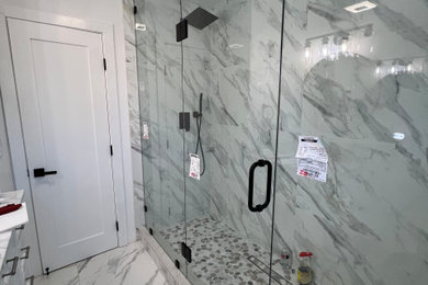 Example of a minimalist porcelain tile, gray floor and double-sink double shower design in Los Angeles with white cabinets, white walls and a hinged shower door