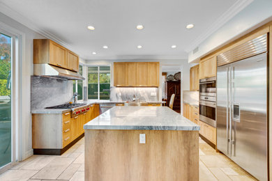 Inspiration for a farmhouse u-shaped eat-in kitchen remodel in Orange County with a farmhouse sink, shaker cabinets, light wood cabinets, stainless steel appliances and an island