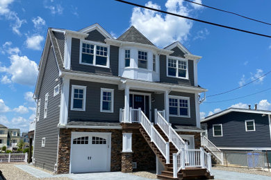 Large transitional blue two-story concrete fiberboard and clapboard exterior home idea in New York with a shingle roof and a black roof